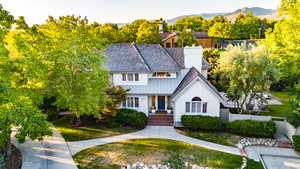 View of front of house featuring a chimney, a mountain view, view of scattered trees, and board and batten siding