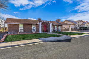 Ranch-style home with a chimney, brick siding, and a shingled roof