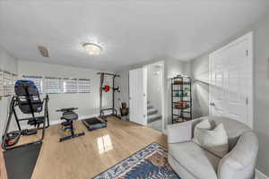 Exercise area with wood finished floors and baseboards
