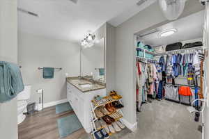 Bathroom with double vanity and a spacious closet