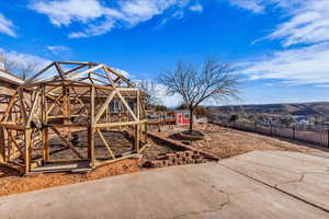 Fenced backyard featuring an outbuilding, exterior structure, and a patio
