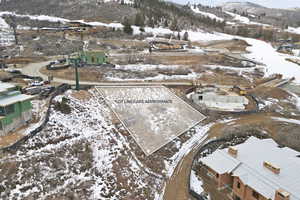 Snowy aerial view featuring a mountain view and property boundaries highlighted