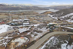 Snowy aerial view featuring a residential view and a water and mountain view