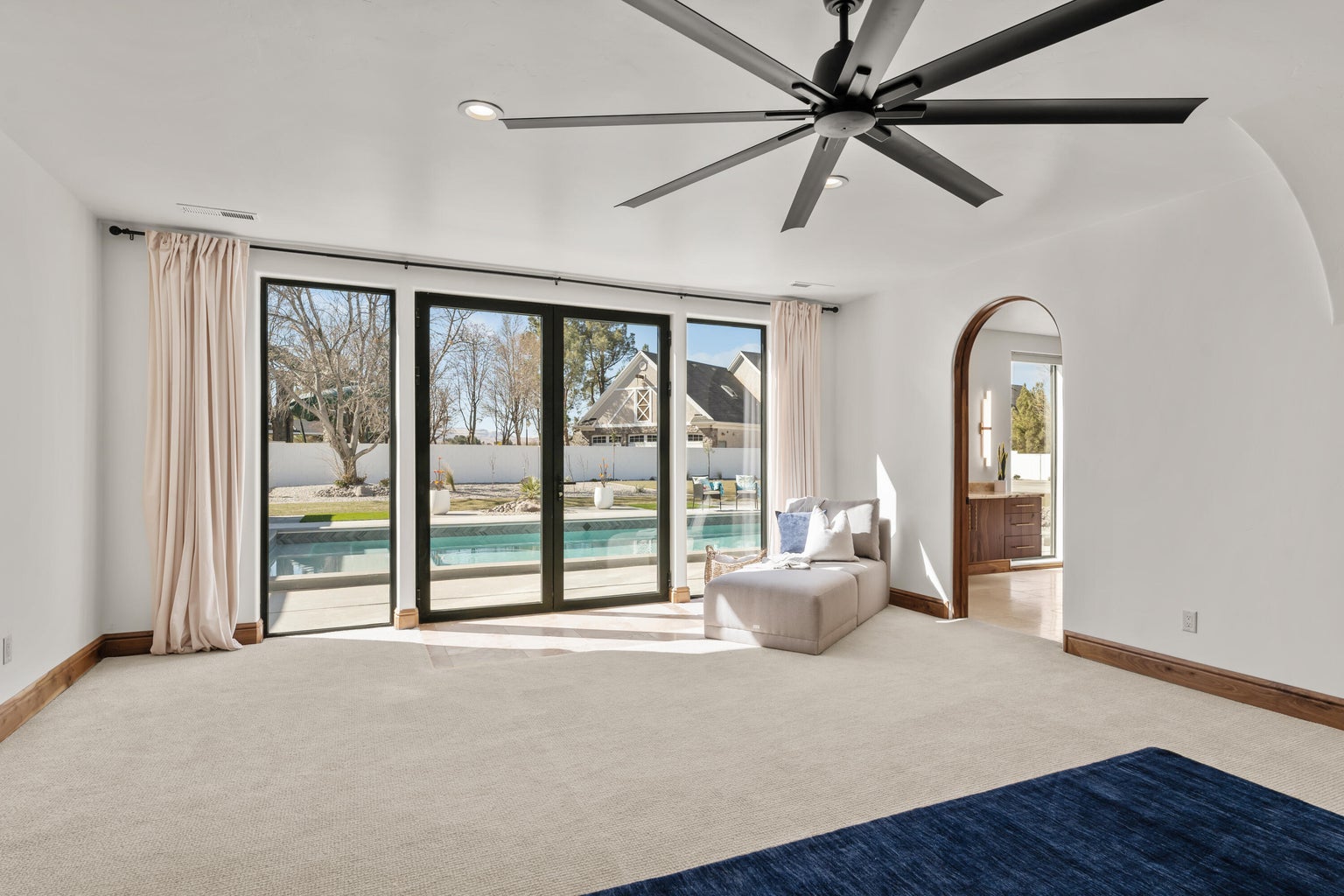 Primary Owner Suite with light carpet, ceiling fan, recessed lighting, and arched walkways