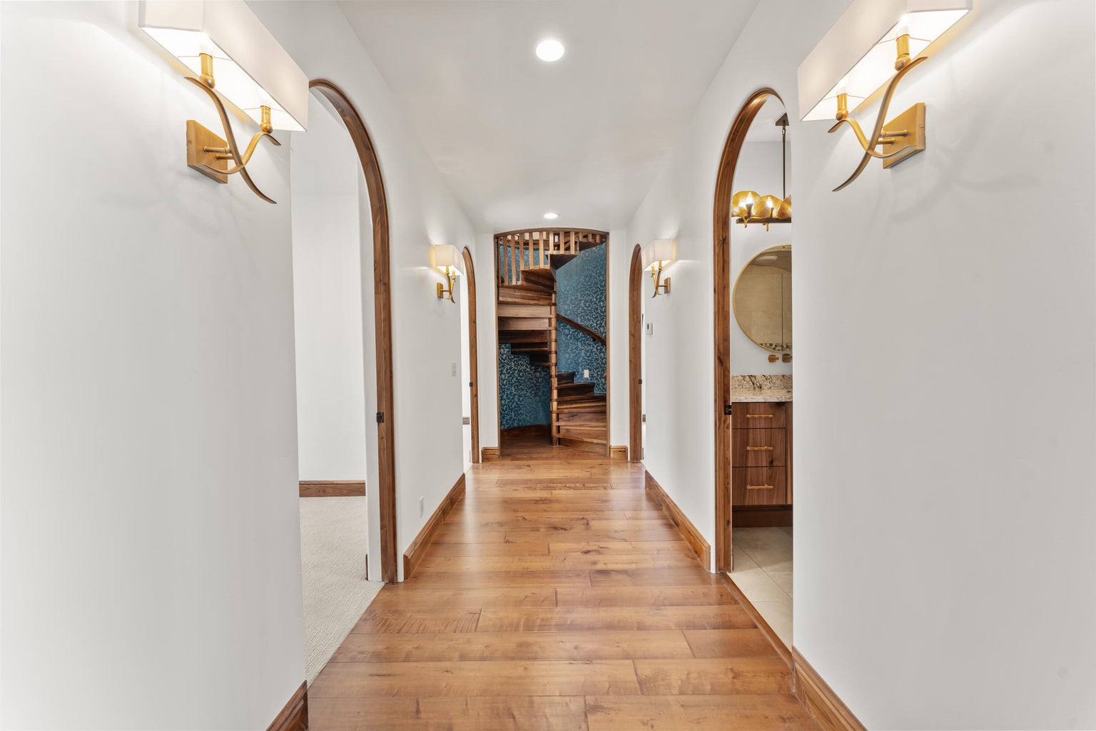 Hallway to 2nd Primary Owner Suite featuring arched walkways, recessed lighting, and light wood-style floors