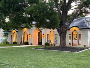View of front facade with stucco siding and a front yard