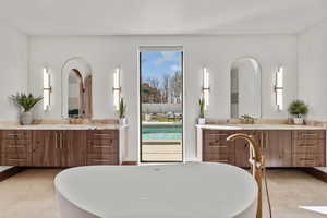 Bathroom featuring a soaking tub and two vanities