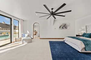 Primary Owner Suite with access to outside, ceiling fan, arched walkways, and recessed lighting