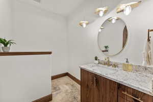 Bathroom featuring vanity and light stone finish floors