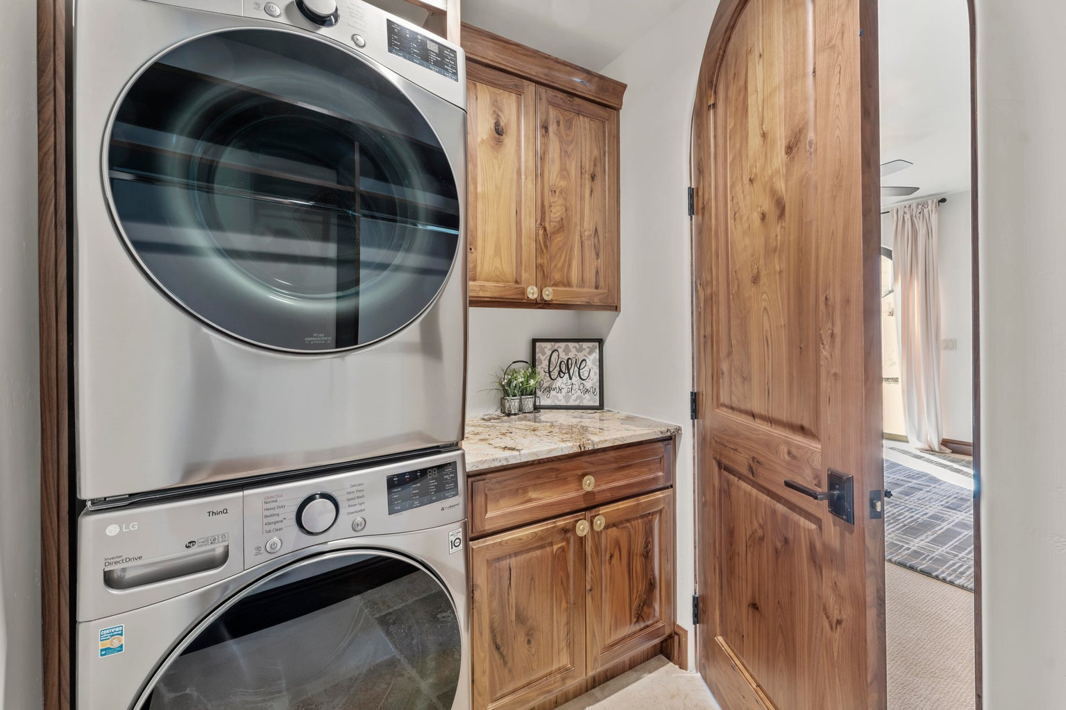 2nd Primary Owner Suite Laundry area with cabinet space and stacked washing machine and dryer