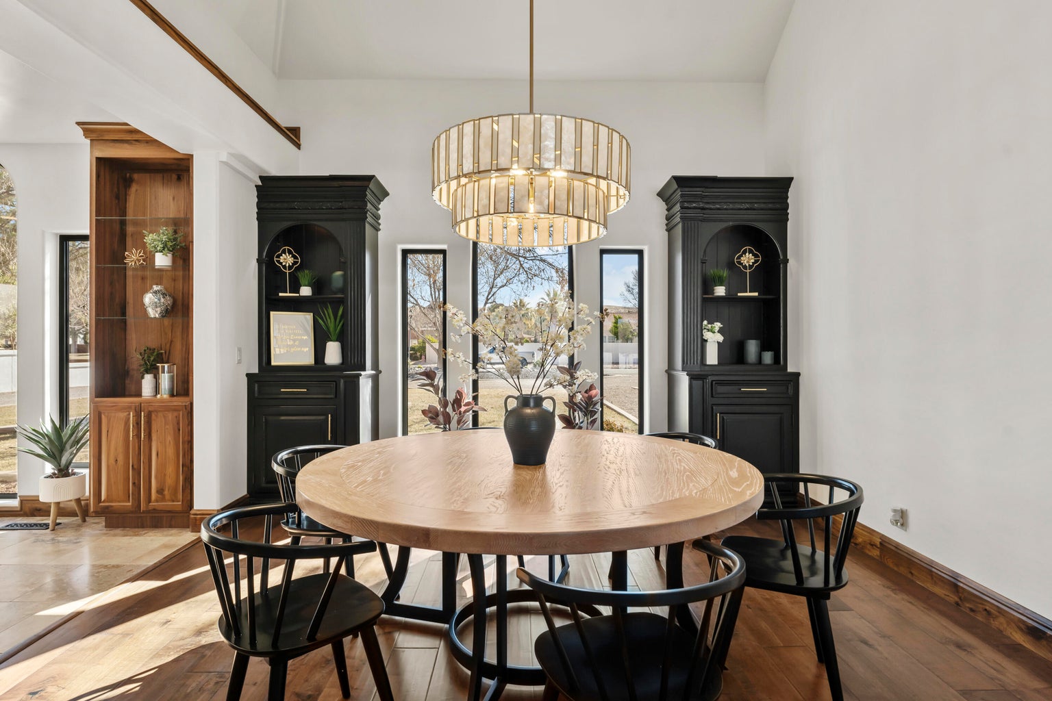 Dining space featuring hardwood / wood-style flooring, hanging lights, and a high ceiling