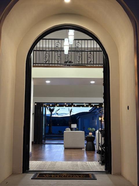 Hall featuring arched walkways, a high ceiling, and recessed lighting