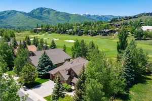Drone / aerial view of a golf course and a mountainous background