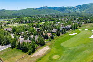 Aerial perspective of suburban area with a local golf course and a mountain backdrop