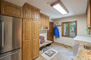 Laundry room with washing machine and clothes dryer, a textured ceiling, and cabinet space