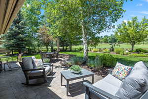Fenced backyard with an outdoor living / dining area, a patio area, and golf course view
