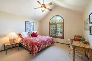Carpeted bedroom featuring a ceiling fan and baseboards