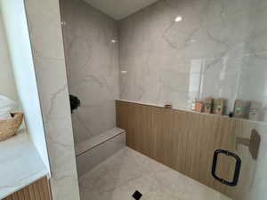 Full bathroom with a marble finish shower
