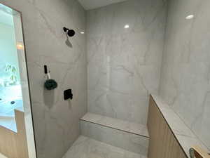 Full bathroom with a marble finish shower