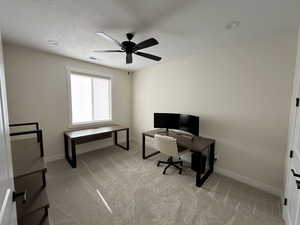 Office space featuring light colored carpet and ceiling fan