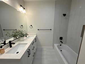 Full bath with double vanity and shower / tub combination