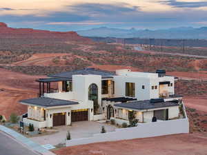 View of front of property with a fenced front yard, stucco siding, a mountain view, driveway, and an attached garage