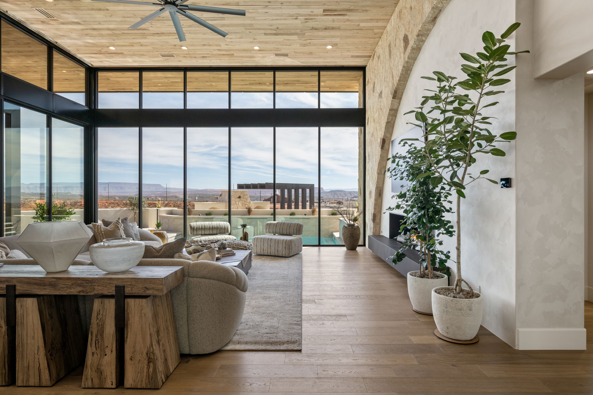 Living area with expansive windows, wooden ceiling, wood-type flooring, a ceiling fan, and a mountain view
