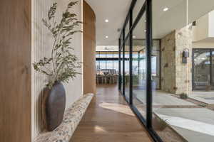 Hallway featuring recessed lighting, wood finished floors, and expansive windows