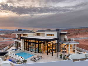 Back of property with a patio, a pool with connected hot tub, and a mountain view