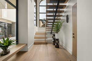 Stairs with hardwood / wood-style flooring and baseboards
