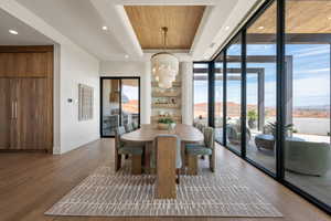 Dining room featuring wood ceiling, dark wood finished floors, a chandelier, and floor to ceiling windows