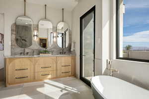 Bathroom with a stall shower, double vanity, a freestanding bath, and decorative backsplash