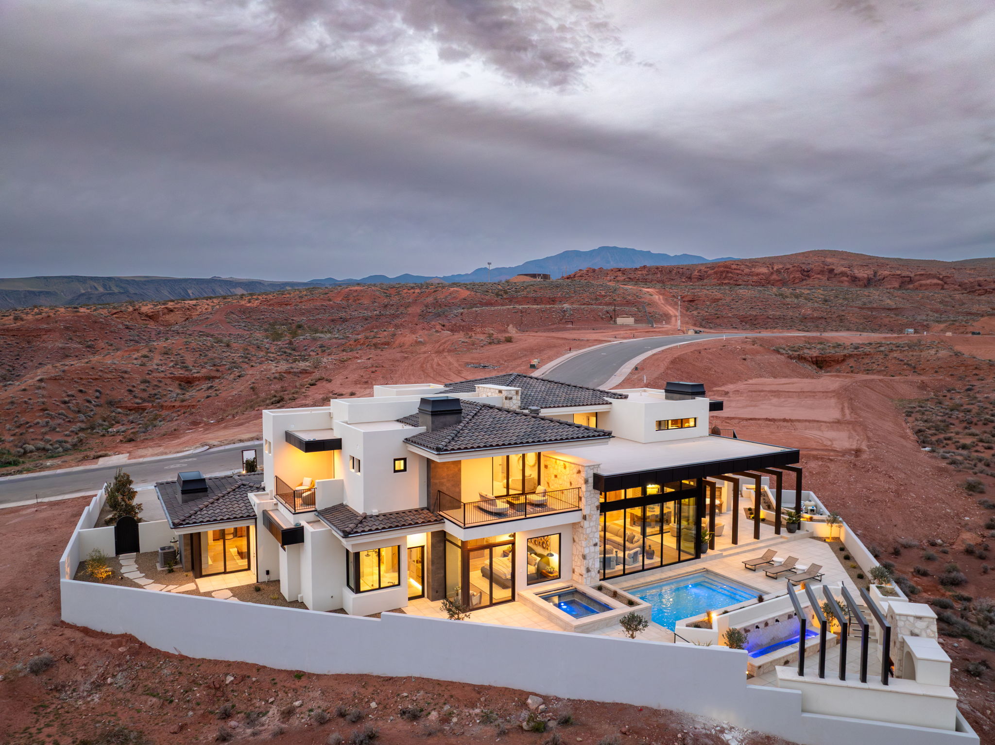 Rear view of house with a patio, a fenced backyard, a pool with connected hot tub, and stucco siding