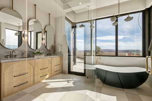 Bathroom featuring double vanity, a soaking tub, a mountain view, a stall shower, and tasteful backsplash