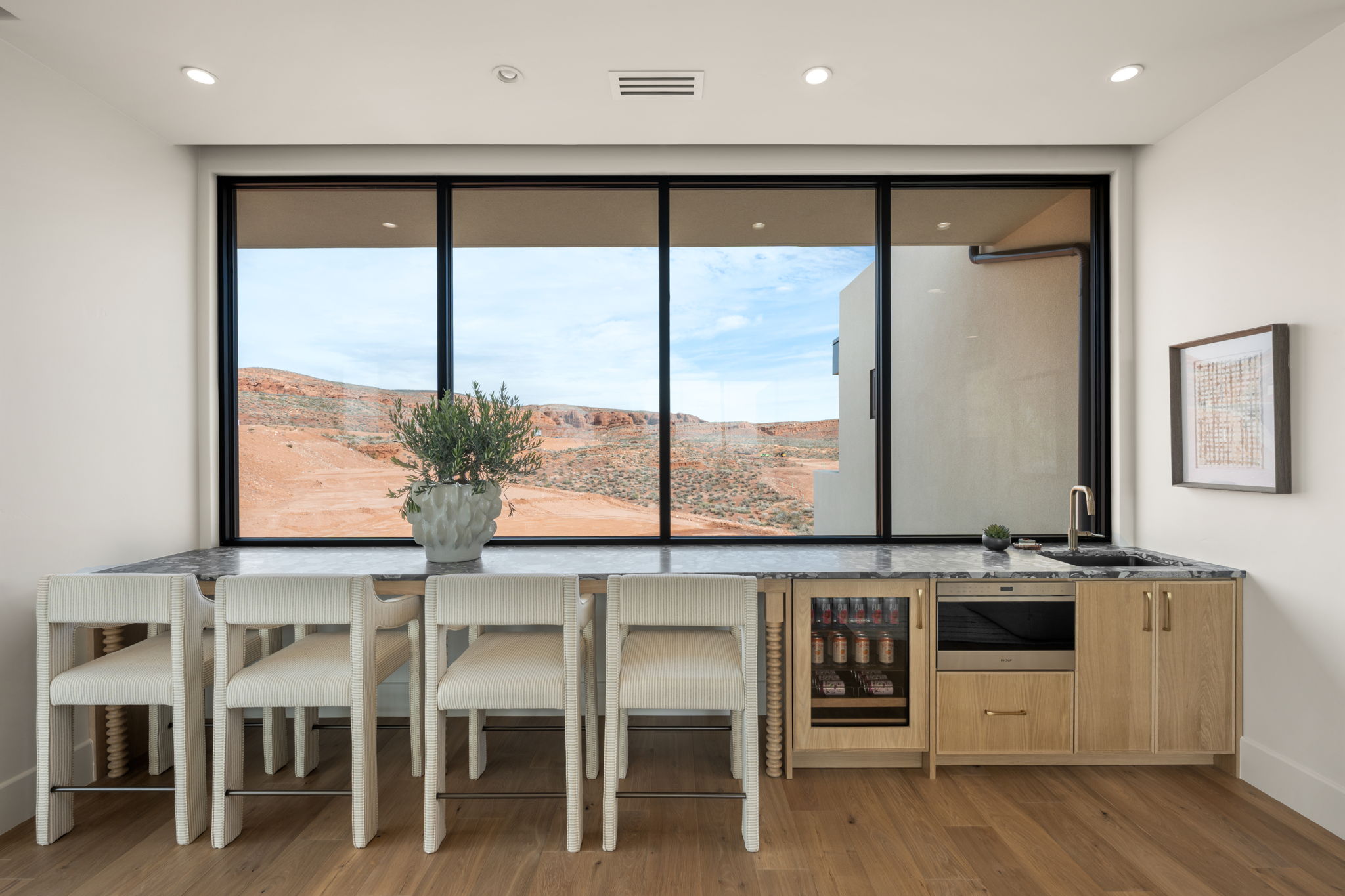 Bar area with wine cooler, stainless steel microwave, light wood-style floors, stone countertops, and recessed lighting