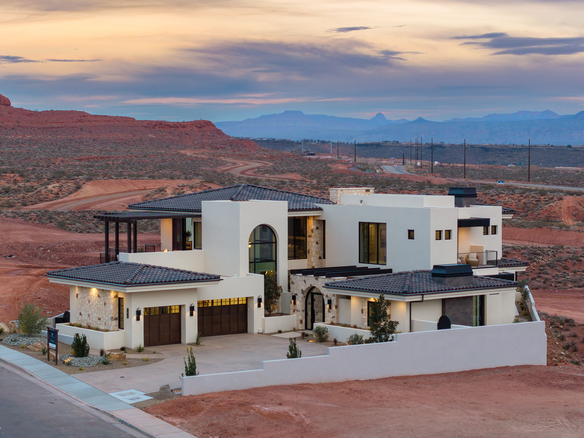 View of front of property with stucco siding, a mountain view, driveway, and stone siding