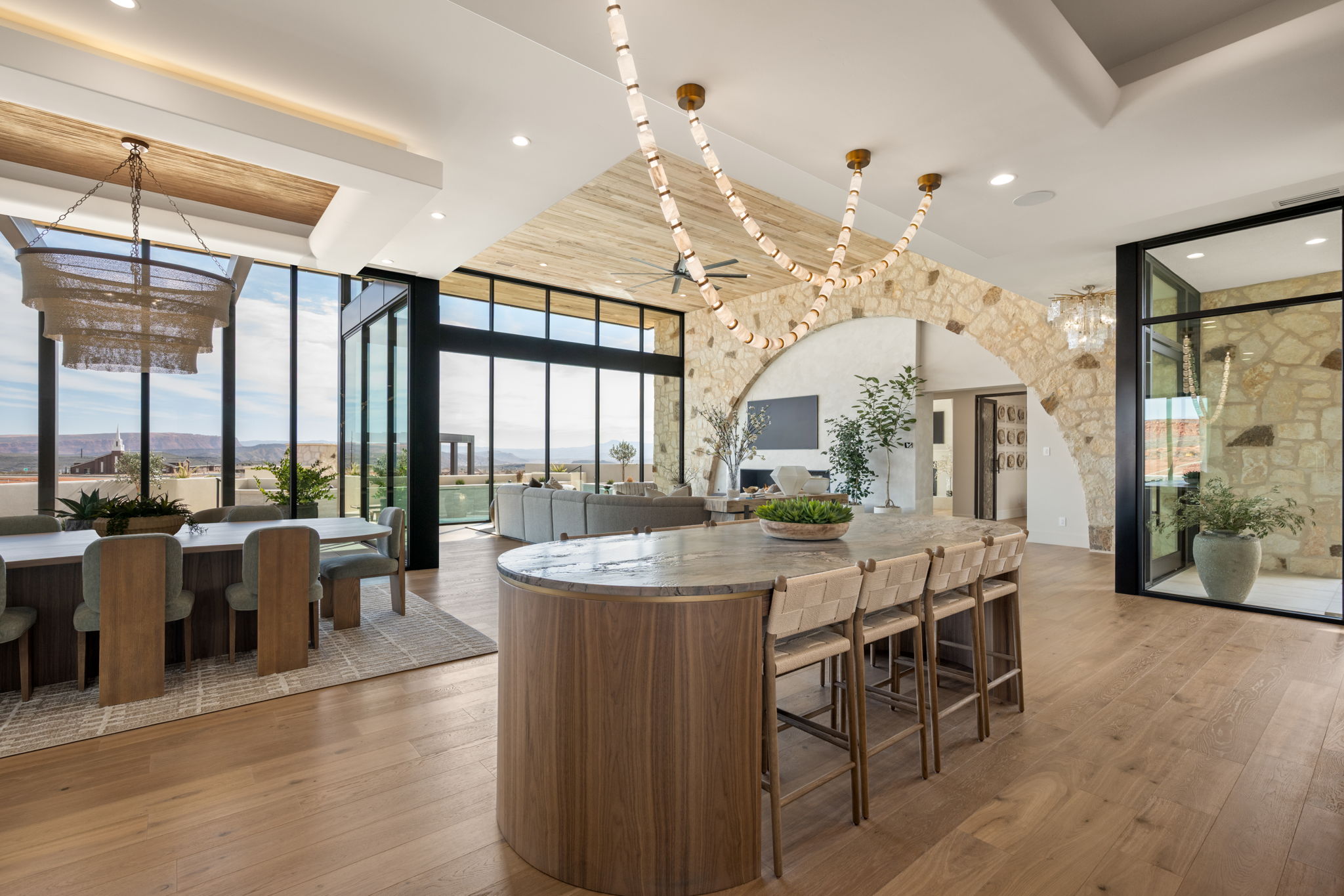 Kitchen with expansive windows, light wood-type flooring, arched walkways, a kitchen island, and a chandelier