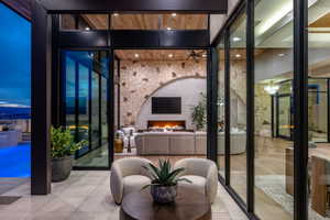 Wine room with a lit fireplace, tile patterned floors, and floor to ceiling windows