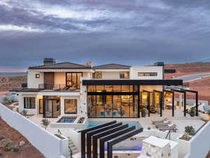 Rear view of house with a chimney, a patio area, a pool with connected hot tub, and stucco siding