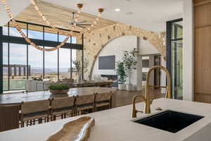 Kitchen with floor to ceiling windows, light stone countertops, and wood finished floors