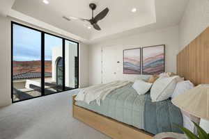 Carpeted bedroom with access to exterior, recessed lighting, ceiling fan, and a tray ceiling
