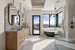 Full bath featuring a stall shower, double vanity, a freestanding tub, and light tile patterned floors