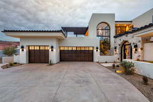 Mediterranean / spanish-style house featuring stucco siding, concrete driveway, and a garage