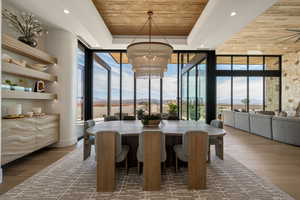 Dining area featuring expansive windows, a wooden tray ceiling, dark wood finished floors, and a chandelier