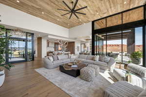 Living area featuring floor to ceiling windows, ceiling fan, wood finished floors, a high wooden ceiling, and a mountain view