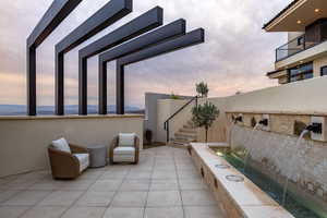 Patio terrace at dusk featuring stairway and a patio