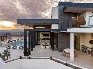 View of pool featuring patio surround and exterior kitchen