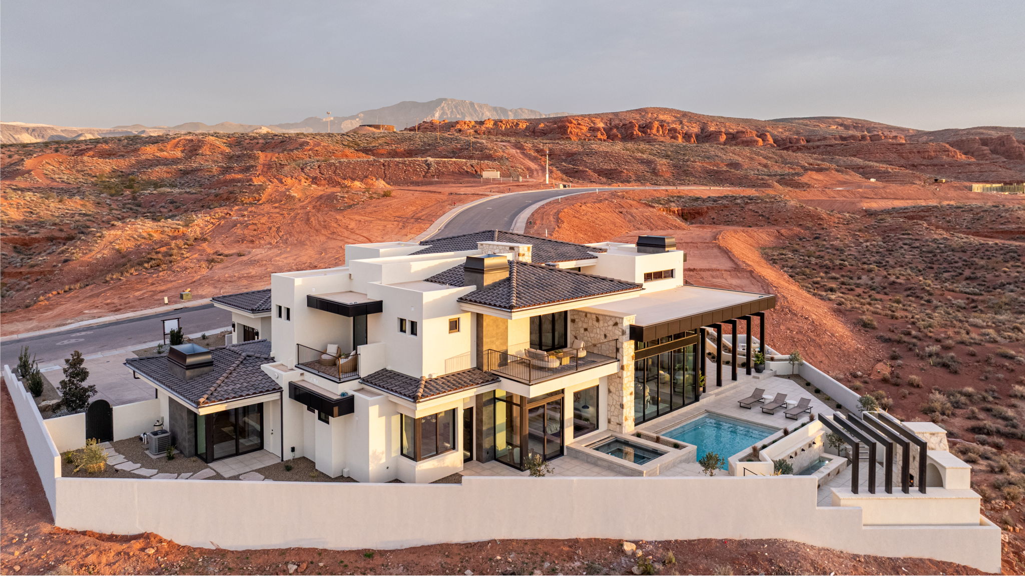 Back of house with a patio area, a fenced backyard, a mountain view, a pool with connected hot tub, and stucco siding