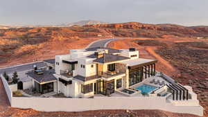 Back of house with a patio area, a fenced backyard, a mountain view, a pool with connected hot tub, and stucco siding