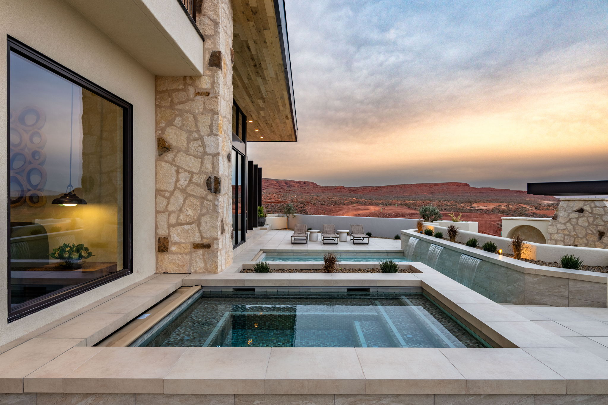 Pool at dusk with an in-ground hot tub and a patio